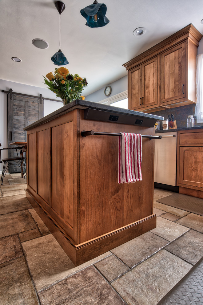 Photo of a medium sized industrial l-shaped kitchen/diner in New York with a submerged sink, beaded cabinets, medium wood cabinets, granite worktops, grey splashback, slate splashback, stainless steel appliances, ceramic flooring, an island and brown floors.