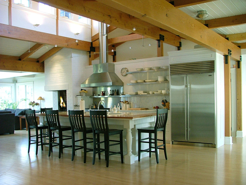 Пример оригинального дизайна: кухня в современном стиле с техникой из нержавеющей стали и барной стойкой