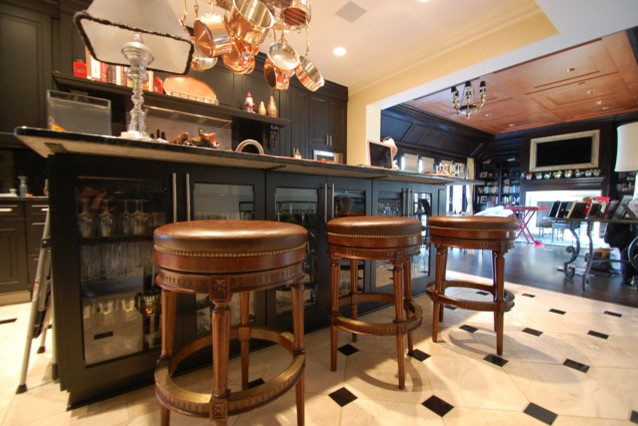 Bild på ett mellanstort funkis kök, med en undermonterad diskho, luckor med upphöjd panel, svarta skåp, granitbänkskiva, svart stänkskydd, stänkskydd i sten, rostfria vitvaror, klinkergolv i keramik och en köksö