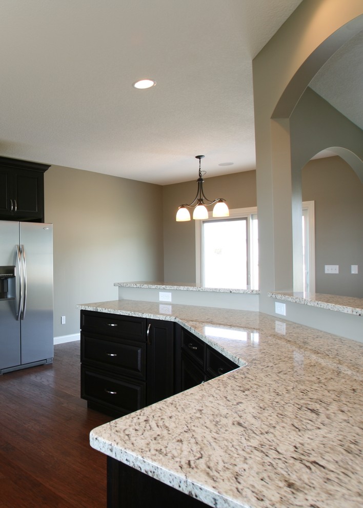 Traditional kitchen in Chicago with dark wood cabinets, granite worktops and stainless steel appliances.