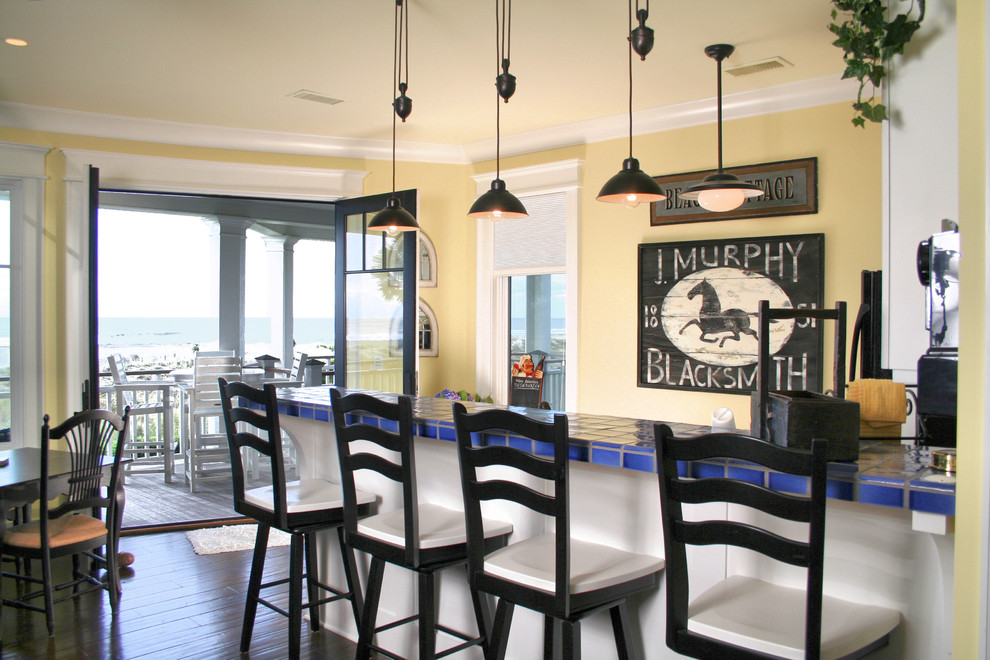 На фото: угловая кухня в классическом стиле с столешницей из плитки, островом, коричневым полом и синей столешницей с