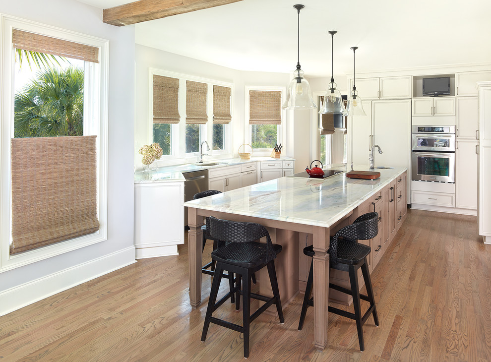 Mid-sized beach style l-shaped light wood floor kitchen photo in Charleston with a drop-in sink, granite countertops, white backsplash, stainless steel appliances and an island