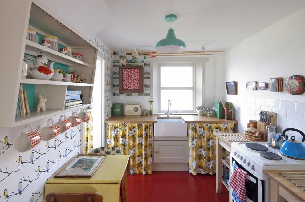 ロンドンにある小さな北欧スタイルのおしゃれなダイニングキッチン (エプロンフロントシンク、木材カウンター、白いキッチンパネル、サブウェイタイルのキッチンパネル、白い調理設備、アイランドなし、壁紙) の写真