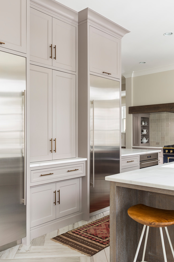 Bild på ett stort kök, med en undermonterad diskho, luckor med infälld panel, grå skåp, marmorbänkskiva, grått stänkskydd, stänkskydd i keramik, klinkergolv i porslin, en köksö och rostfria vitvaror