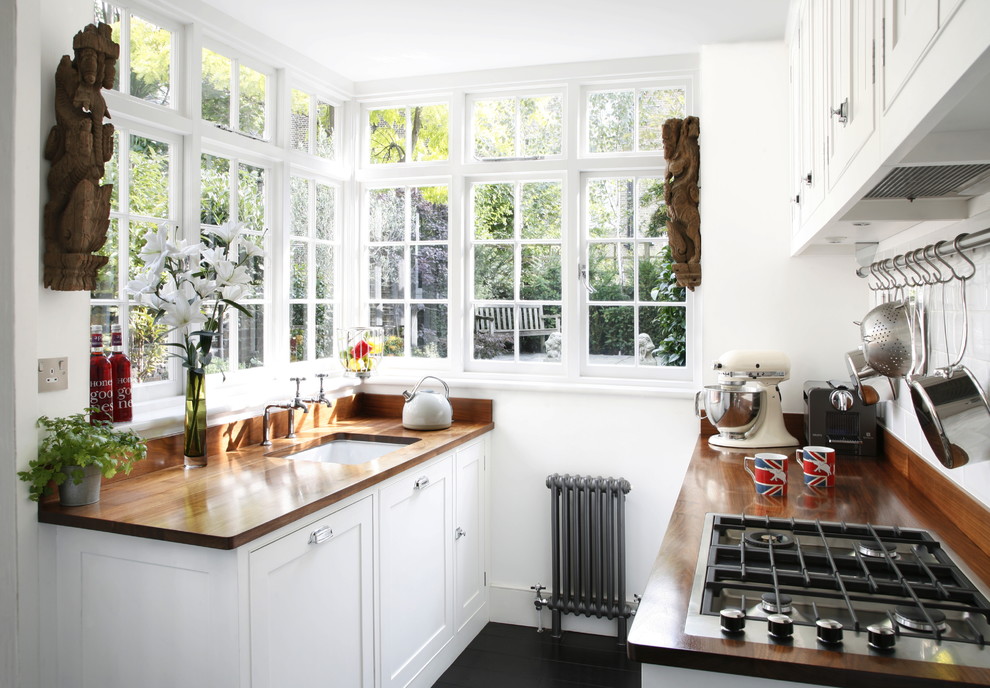 Zweizeilige, Kleine Klassische Schmale Küche mit Unterbauwaschbecken, Schrankfronten im Shaker-Stil, weißen Schränken, Arbeitsplatte aus Holz und Küchenrückwand in Weiß in London