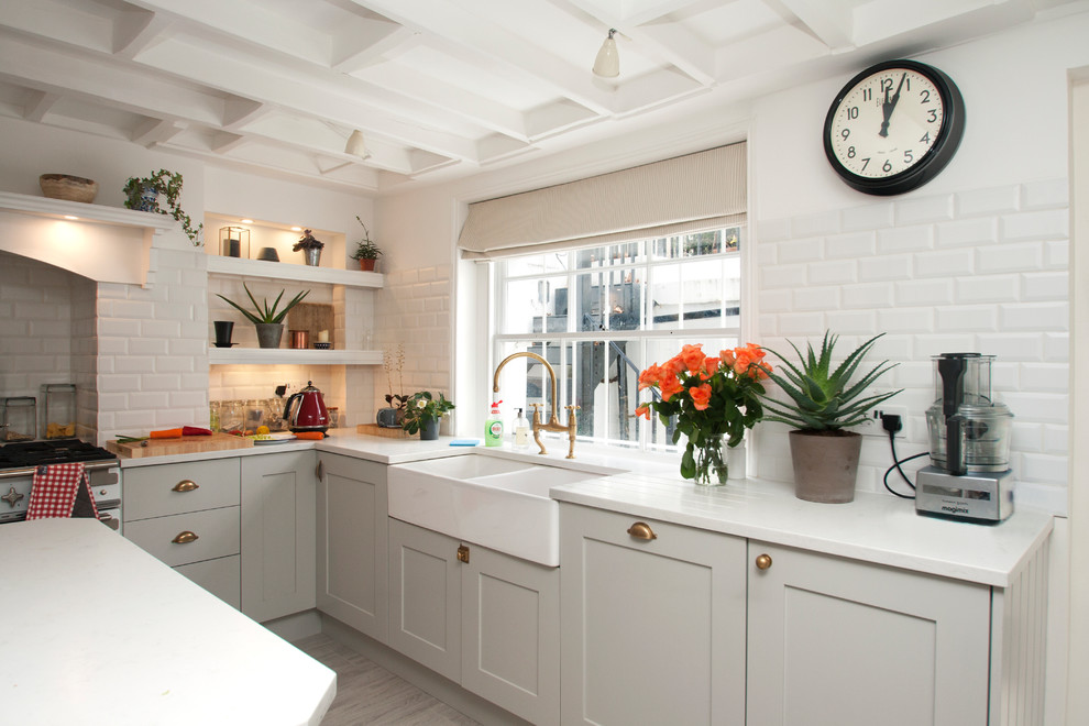 Bild på ett stort vintage vit vitt kök, med en rustik diskho, skåp i shakerstil, grå skåp, granitbänkskiva, vitt stänkskydd, stänkskydd i tunnelbanekakel, färgglada vitvaror, mellanmörkt trägolv och en köksö