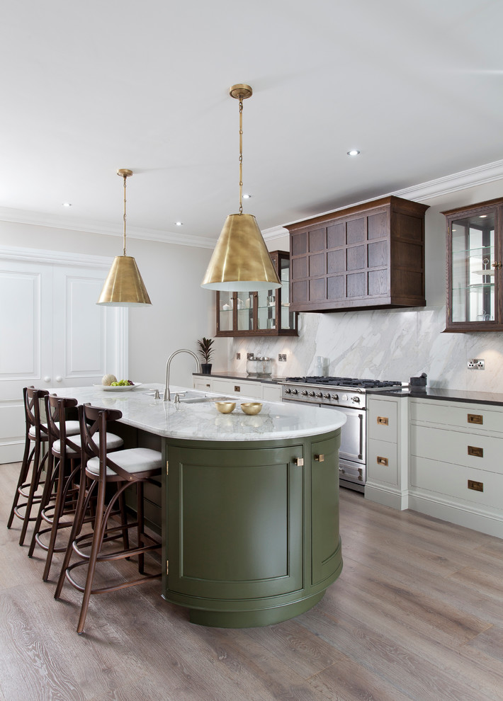 This is an example of a classic galley kitchen in Dublin with a submerged sink, beaded cabinets, marble worktops, stainless steel appliances, light hardwood flooring and an island.