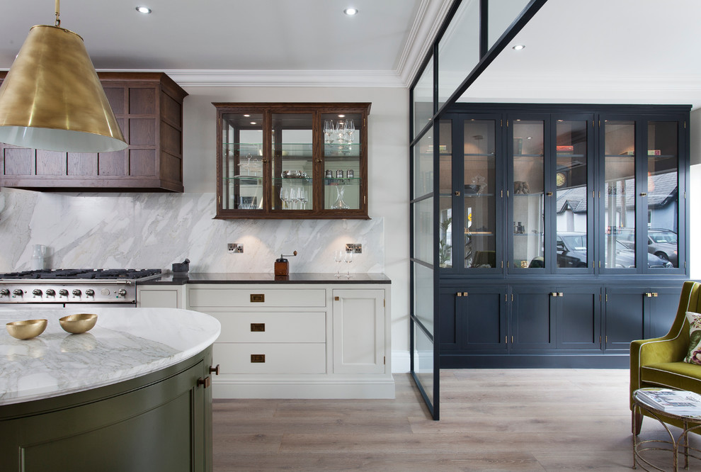 Photo of a contemporary galley kitchen in Dublin with a submerged sink, beaded cabinets, marble worktops, stainless steel appliances, light hardwood flooring and an island.