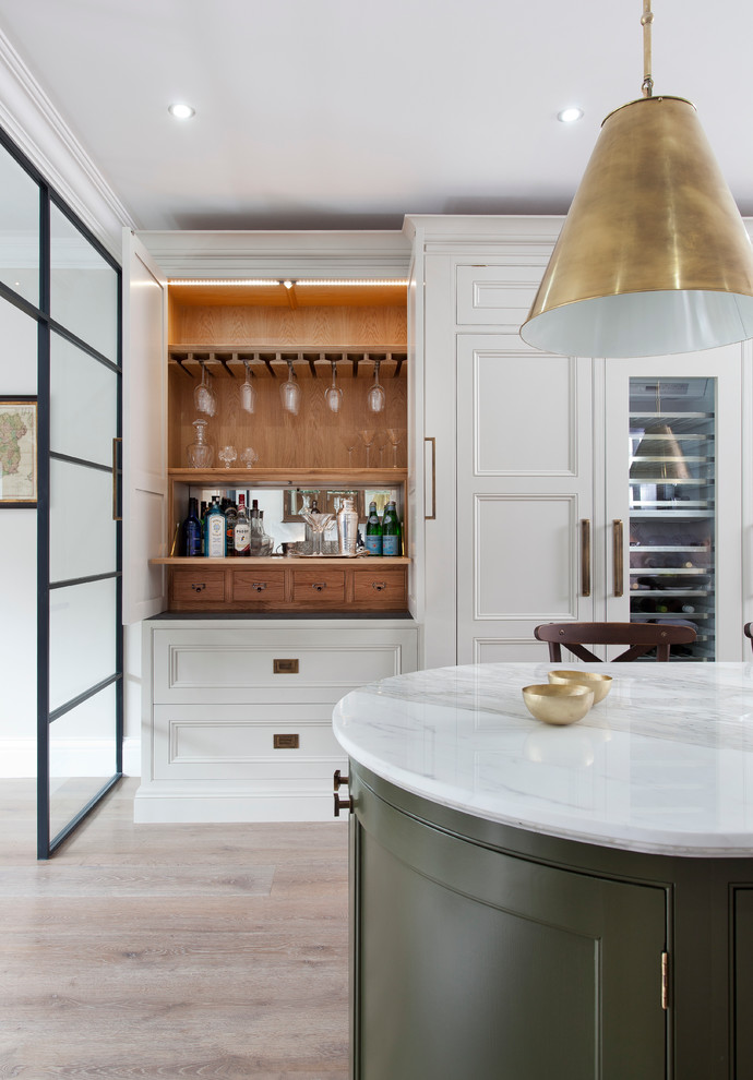 Immagine di una cucina minimal con lavello sottopiano, ante a filo, top in marmo, elettrodomestici in acciaio inossidabile e parquet chiaro
