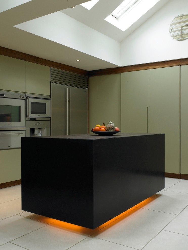 Design ideas for a medium sized contemporary open plan kitchen in London with an integrated sink, flat-panel cabinets, green cabinets, granite worktops, glass sheet splashback, stainless steel appliances, porcelain flooring and an island.