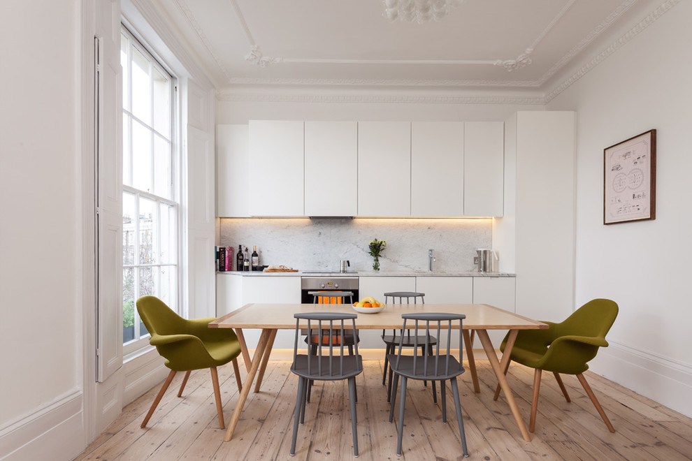 Example of a danish kitchen design in London with marble backsplash