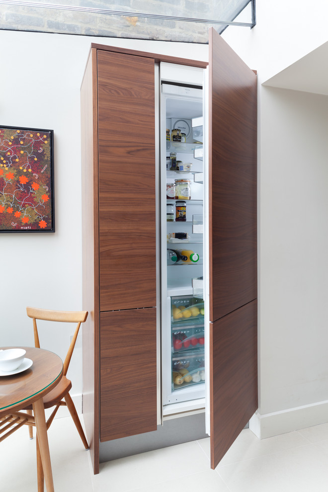 Kitchen - contemporary kitchen idea in London with flat-panel cabinets, paneled appliances and dark wood cabinets