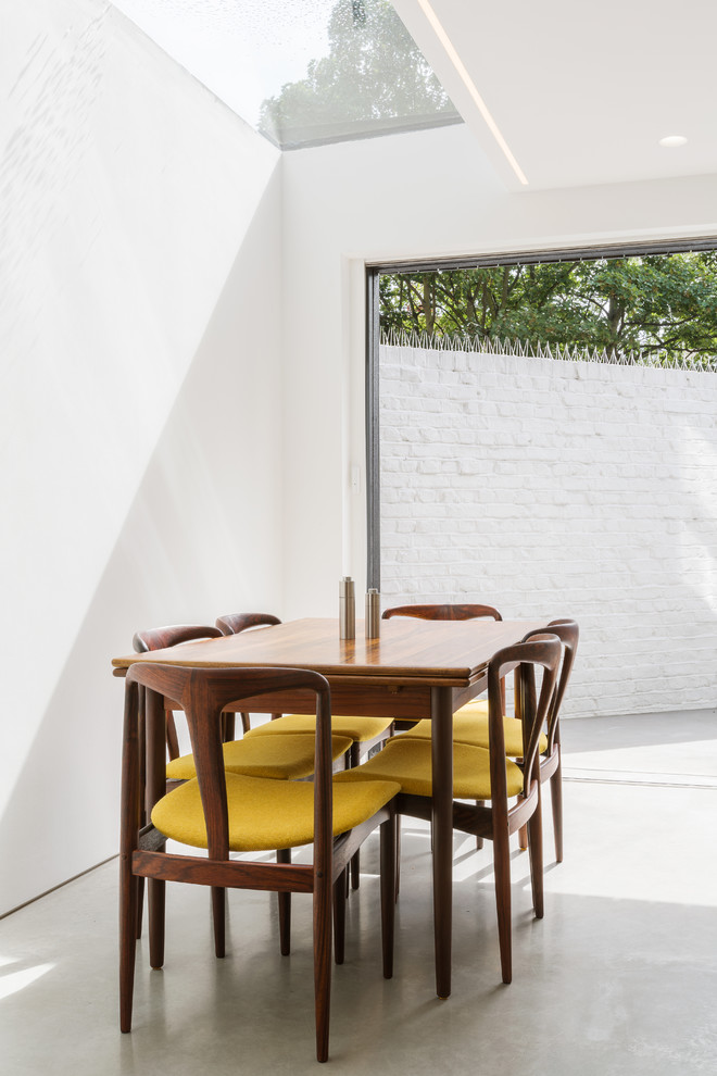 Foto di una sala da pranzo aperta verso il soggiorno contemporanea di medie dimensioni con pavimento in cemento e pavimento grigio