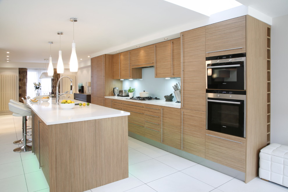 Immagine di una cucina parallela design con ante lisce e ante in legno chiaro