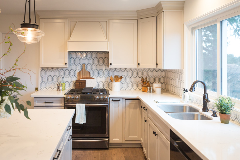 Exempel på ett mellanstort klassiskt vit vitt kök, med en undermonterad diskho, skåp i shakerstil, vita skåp, bänkskiva i kvartsit, flerfärgad stänkskydd, stänkskydd i keramik, rostfria vitvaror, laminatgolv, en köksö och brunt golv