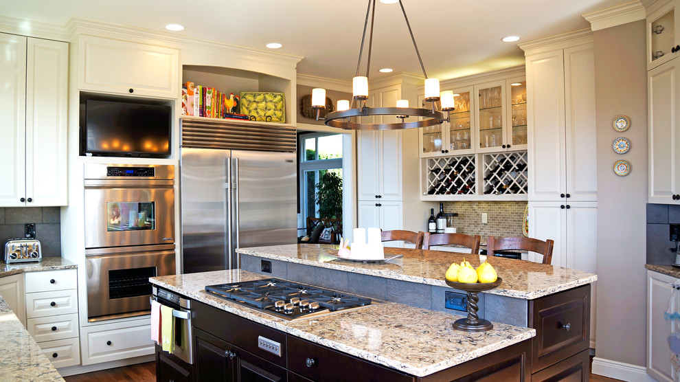 Example of a mid-sized classic u-shaped medium tone wood floor eat-in kitchen design in Seattle with an undermount sink, raised-panel cabinets, white cabinets, quartzite countertops, beige backsplash, porcelain backsplash, stainless steel appliances and an island