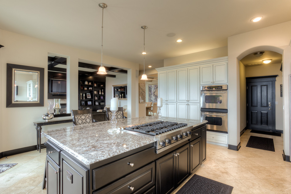 Immagine di una cucina chic di medie dimensioni con lavello sottopiano, top in granito, elettrodomestici in acciaio inossidabile, pavimento in marmo, ante a persiana, ante in legno chiaro e paraspruzzi nero