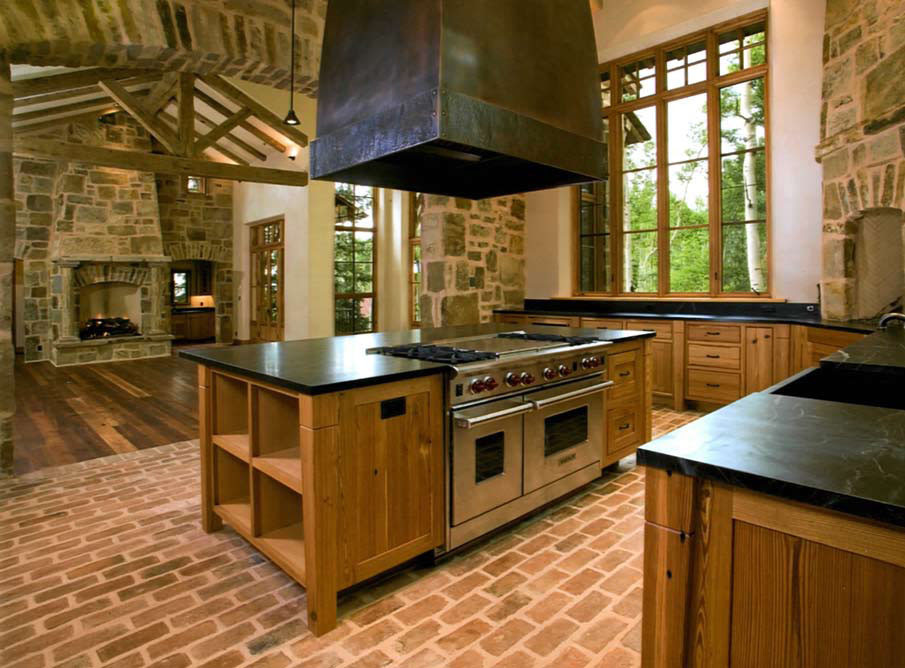 Exempel på ett stort amerikanskt kök, med en rustik diskho, luckor med upphöjd panel, skåp i mellenmörkt trä, bänkskiva i täljsten, beige stänkskydd, stänkskydd i keramik, rostfria vitvaror, tegelgolv och en köksö