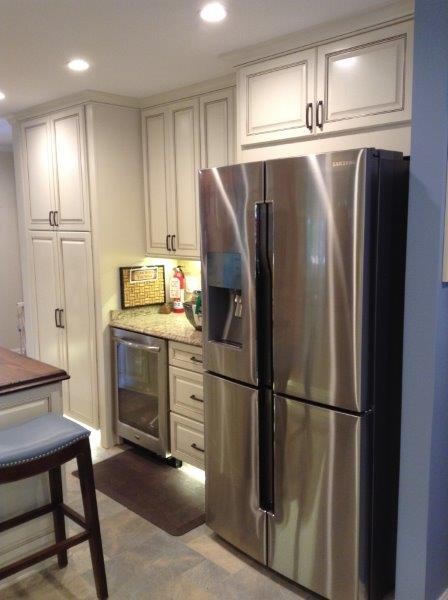 This is an example of an expansive mediterranean galley kitchen/diner in Baltimore with a submerged sink, raised-panel cabinets, beige cabinets, wood worktops, beige splashback, stone tiled splashback, stainless steel appliances, porcelain flooring and an island.