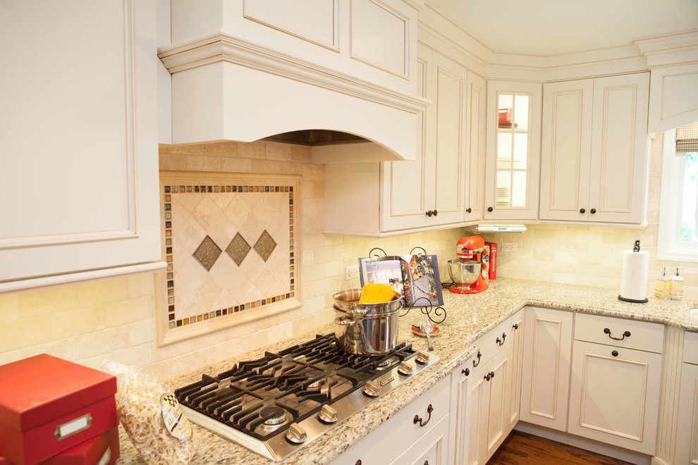 Large trendy u-shaped medium tone wood floor eat-in kitchen photo in Chicago with an undermount sink, recessed-panel cabinets, white cabinets, granite countertops, beige backsplash, stone slab backsplash, stainless steel appliances and an island