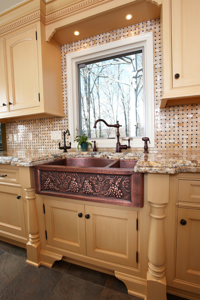 Foto på ett stort vintage kök, med en rustik diskho, luckor med infälld panel, gula skåp, granitbänkskiva, flerfärgad stänkskydd, stänkskydd i stenkakel, skiffergolv och en köksö