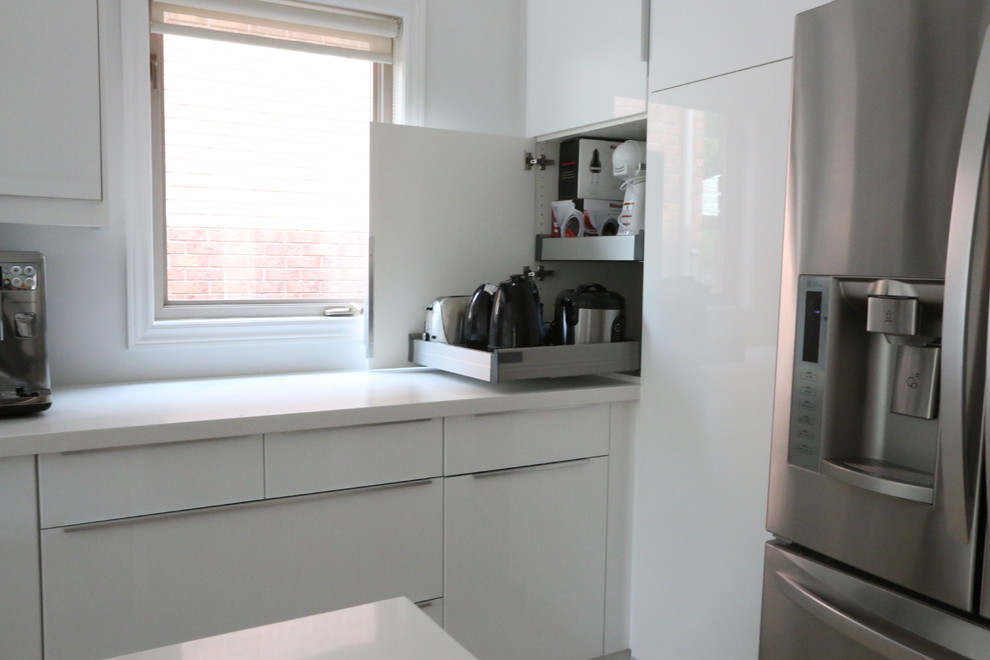 Immagine di una cucina minimalista di medie dimensioni con lavello sottopiano, ante lisce, ante bianche, top in quarzo composito, paraspruzzi bianco, elettrodomestici in acciaio inossidabile e pavimento in vinile