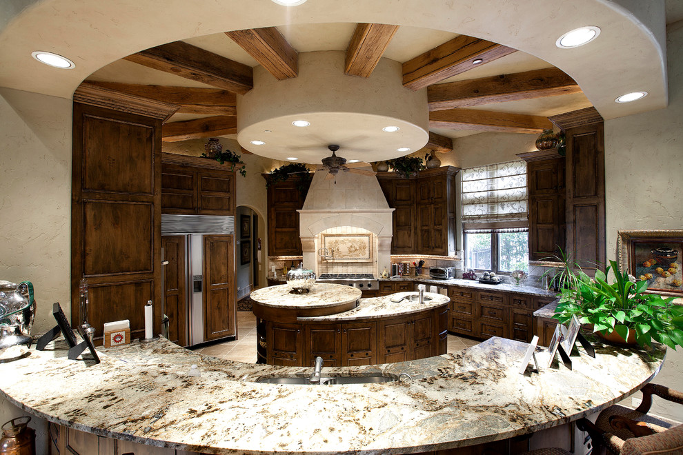 Kitchen - mediterranean kitchen idea in Dallas with recessed-panel cabinets, dark wood cabinets and paneled appliances