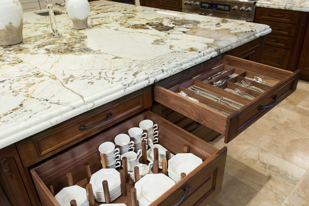 Example of a large classic u-shaped travertine floor open concept kitchen design in Denver with an undermount sink, raised-panel cabinets, distressed cabinets, granite countertops, multicolored backsplash, mosaic tile backsplash, paneled appliances and an island