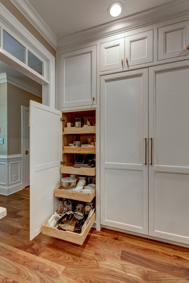 Inspiration for a large traditional u-shaped open plan kitchen in Raleigh with beaded cabinets, white cabinets, integrated appliances, dark hardwood flooring and an island.