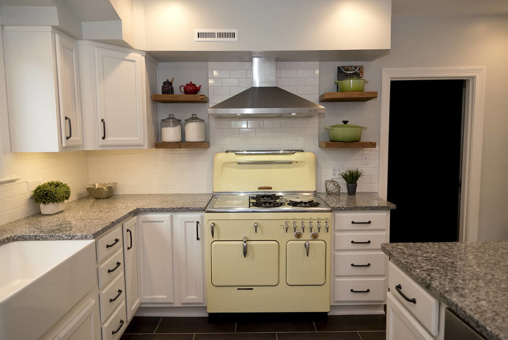 Example of a small minimalist l-shaped porcelain tile and gray floor enclosed kitchen design in Baltimore with a farmhouse sink, recessed-panel cabinets, white cabinets, granite countertops, yellow backsplash, ceramic backsplash, stainless steel appliances and a peninsula