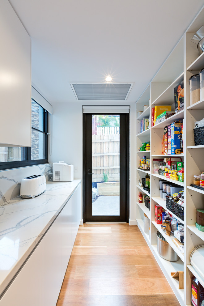 Moderne Küche mit offenen Schränken, Küchenrückwand in Weiß, braunem Holzboden, braunem Boden und weißer Arbeitsplatte in Melbourne