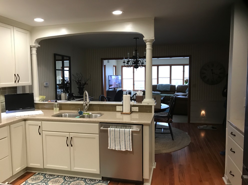 Medium sized traditional u-shaped open plan kitchen in Other with recessed-panel cabinets, beige cabinets, laminate countertops and a breakfast bar.