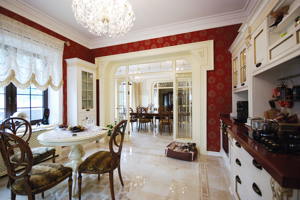 На фото: большая отдельная, прямая кухня в классическом стиле с белыми фасадами, столешницей из кварцита, белым фартуком, фартуком из плитки мозаики, черной техникой и мраморным полом в частном доме