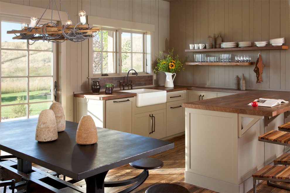 Photo of a small rustic u-shaped kitchen/diner in Other with a belfast sink, open cabinets, wood worktops, medium hardwood flooring, a breakfast bar, brown splashback, brown floors and brown worktops.