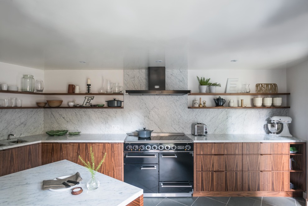 This is an example of a medium sized midcentury kitchen in London with dark wood cabinets, marble worktops and an island.