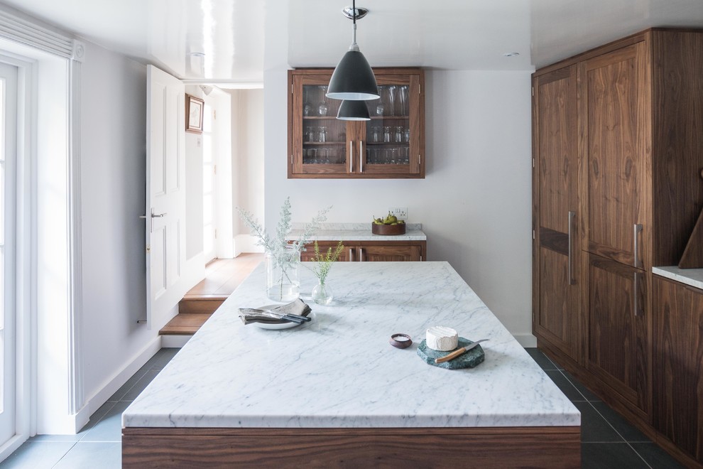 Ejemplo de cocina retro de tamaño medio con puertas de armario de madera en tonos medios, encimera de mármol y una isla