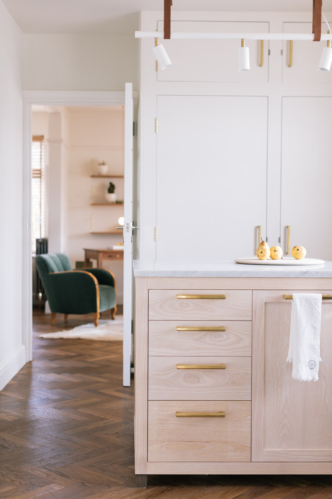 Foto på ett minimalistiskt kök, med marmorbänkskiva och en köksö