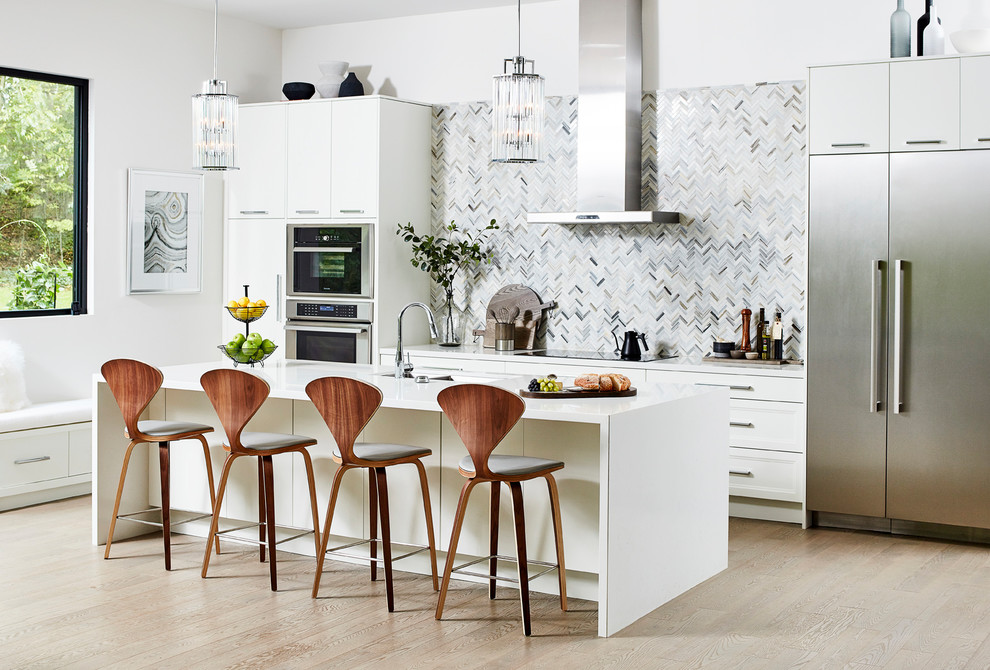 Inspiration for a large contemporary galley kitchen in Toronto with recessed-panel cabinets, white cabinets, grey splashback, mosaic tiled splashback, stainless steel appliances, light hardwood flooring, an island, beige floors and white worktops.