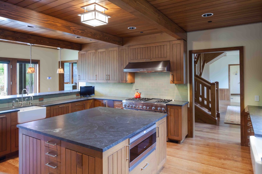 Idéer för att renovera ett avskilt, mycket stort rustikt l-kök, med en rustik diskho, luckor med profilerade fronter, skåp i mellenmörkt trä, granitbänkskiva, grönt stänkskydd, stänkskydd i keramik, rostfria vitvaror, ljust trägolv och en köksö