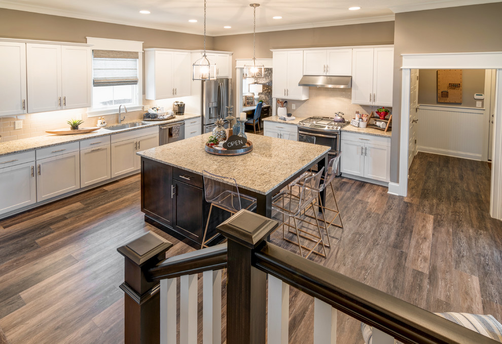 Inspiration for a large craftsman single-wall dark wood floor eat-in kitchen remodel in Indianapolis with a single-bowl sink, shaker cabinets, white cabinets, granite countertops, beige backsplash, subway tile backsplash, stainless steel appliances and an island