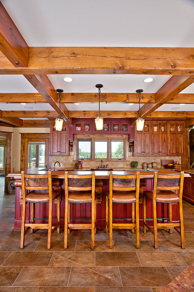 Immagine di una cucina stile rurale con lavello sottopiano, ante con riquadro incassato, ante rosse, paraspruzzi beige e pavimento marrone