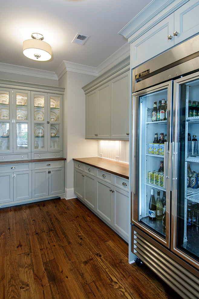 Modelo de cocina clásica con electrodomésticos de acero inoxidable, encimera de madera, armarios con paneles empotrados y puertas de armario azules