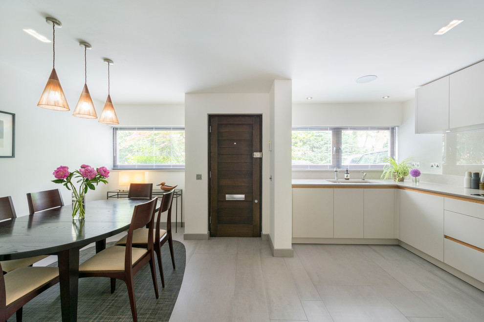 Foto de cocina moderna sin isla con armarios con paneles lisos, puertas de armario blancas y suelo de madera en tonos medios