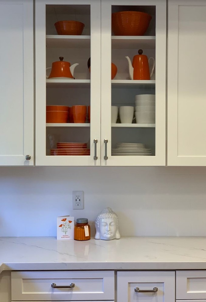 Inspiration för ett mellanstort rustikt vit vitt kök och matrum, med en rustik diskho, luckor med upphöjd panel, vita skåp, bänkskiva i kvarts, vitt stänkskydd, rostfria vitvaror, en köksö och brunt golv