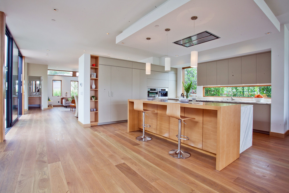 Esempio di una grande cucina minimalista con ante lisce, ante grigie, top in marmo, elettrodomestici in acciaio inossidabile e pavimento in legno massello medio