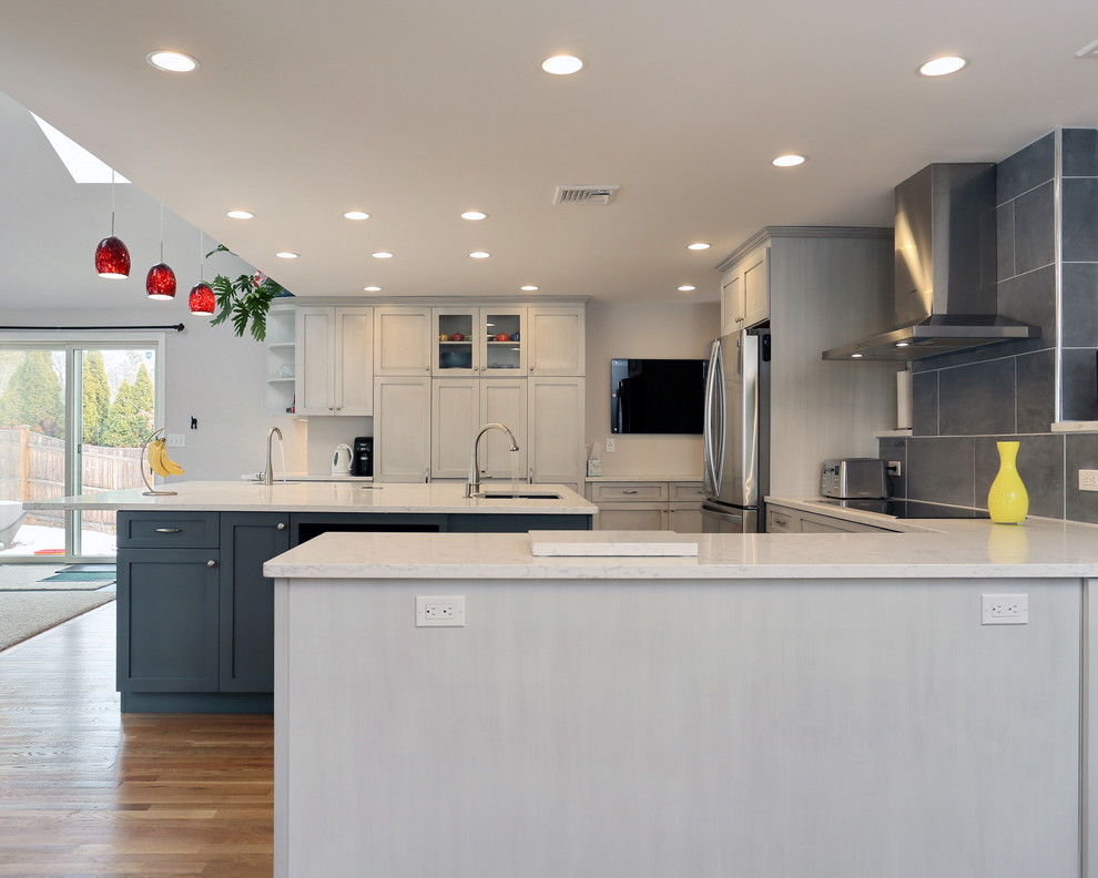 Inspiration for a large modern u-shaped kitchen/diner in Boston with a submerged sink, shaker cabinets, grey cabinets, engineered stone countertops, grey splashback, porcelain splashback, stainless steel appliances, painted wood flooring and multiple islands.