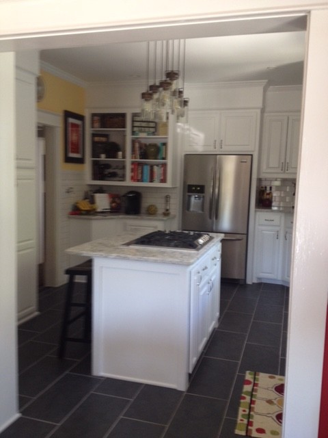 Foto på ett mellanstort funkis u-kök, med en rustik diskho, luckor med upphöjd panel, vita skåp, bänkskiva i kvarts, vitt stänkskydd, stänkskydd i tunnelbanekakel, rostfria vitvaror, klinkergolv i keramik och en köksö