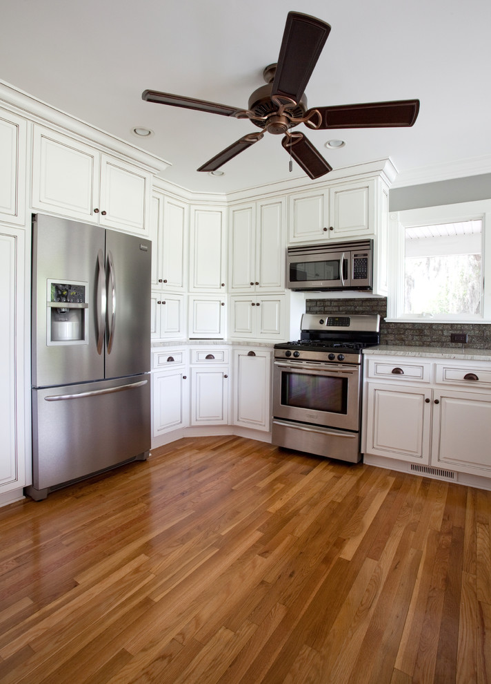 Kitchen - large tropical light wood floor kitchen idea in Charleston with yellow cabinets and stainless steel appliances