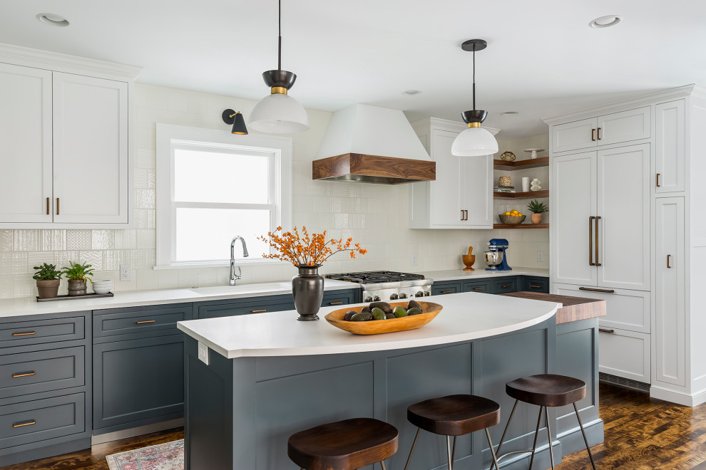 Design ideas for a large traditional l-shaped kitchen/diner in Minneapolis with a submerged sink, flat-panel cabinets, blue cabinets, engineered stone countertops, white splashback, ceramic splashback, integrated appliances, dark hardwood flooring, an island, brown floors and white worktops.