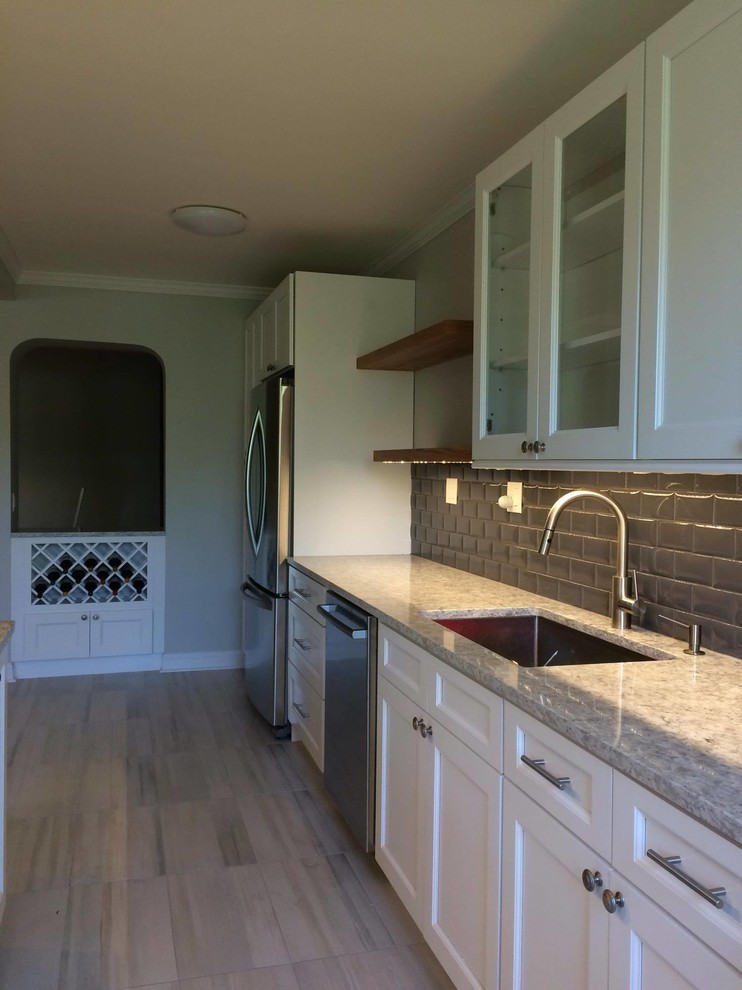 Exempel på ett mellanstort klassiskt flerfärgad flerfärgat kök, med en enkel diskho, skåp i shakerstil, vita skåp, bänkskiva i kvartsit, grått stänkskydd, stänkskydd i tunnelbanekakel, rostfria vitvaror, en halv köksö, vinylgolv och beiget golv